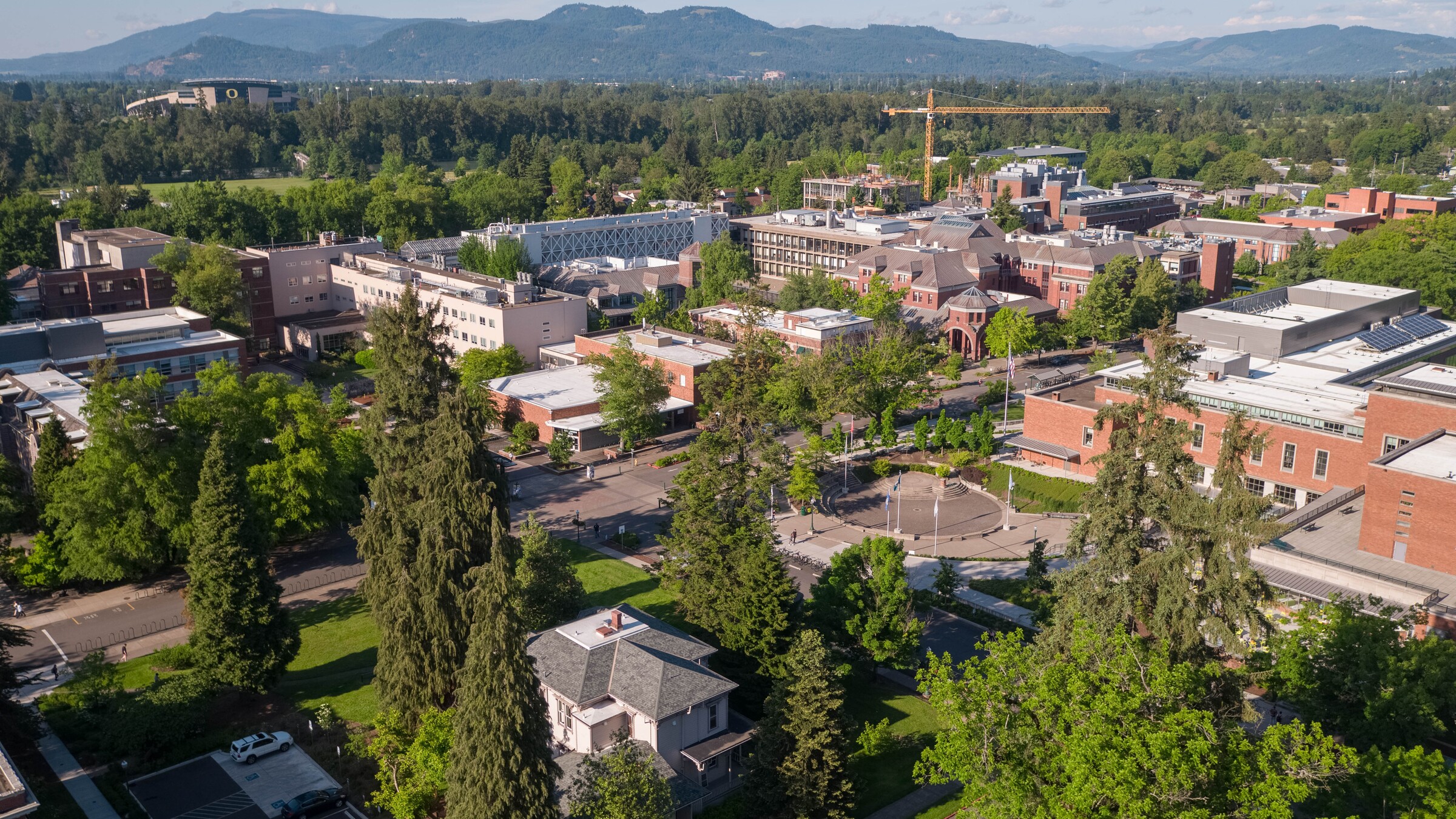 UO campus buildings and trees stretch toward distant hills.