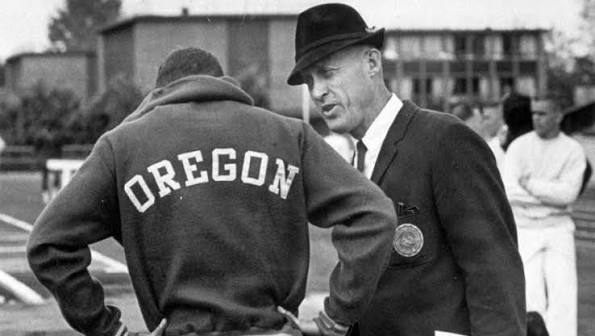 A historical photo of Oregon track coach Bill Bowerman talking to an athlete