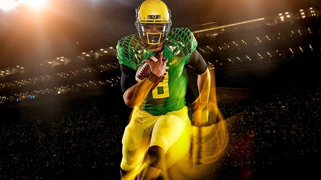Marcus Mariota in an Oregon uniform running with a football