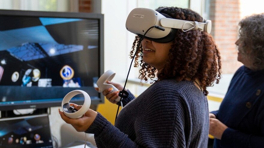 People explore an immersive media demonstration with a headset.