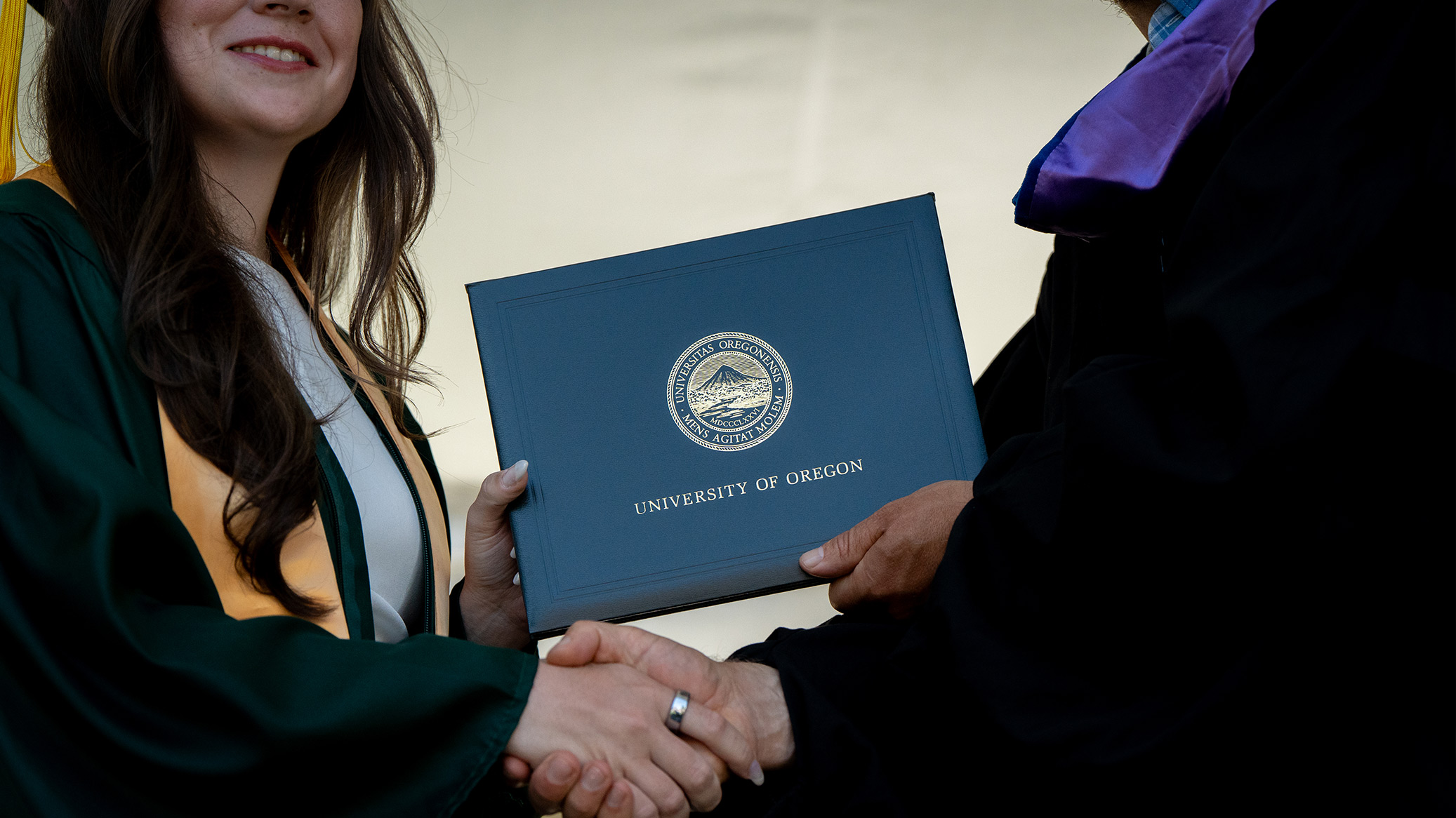 University of Oregon student with diploma