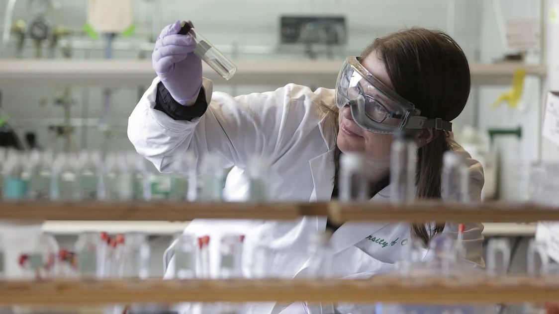 A student holding up a sample in a lab