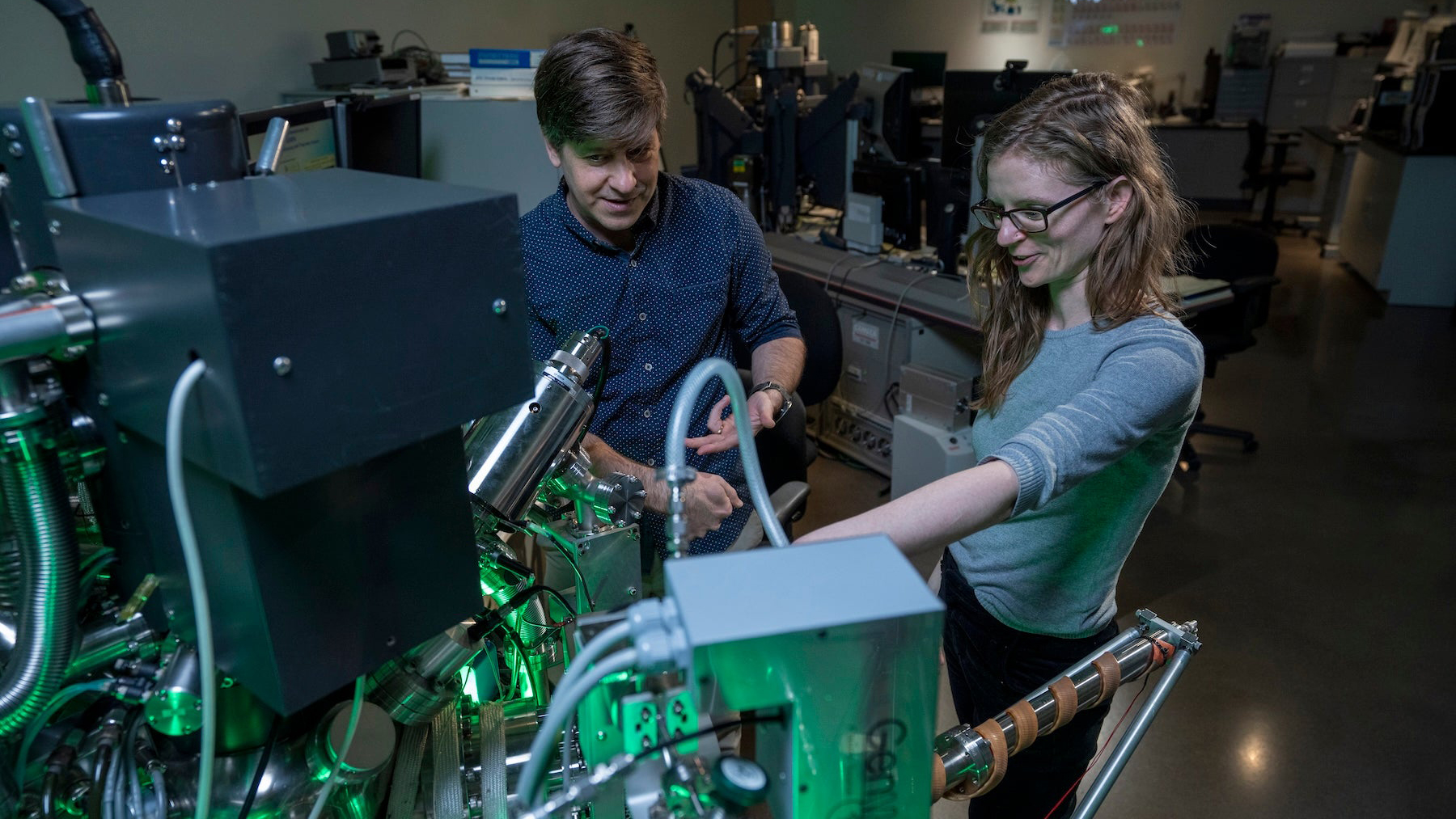 Student and faculty member working on a large computer.