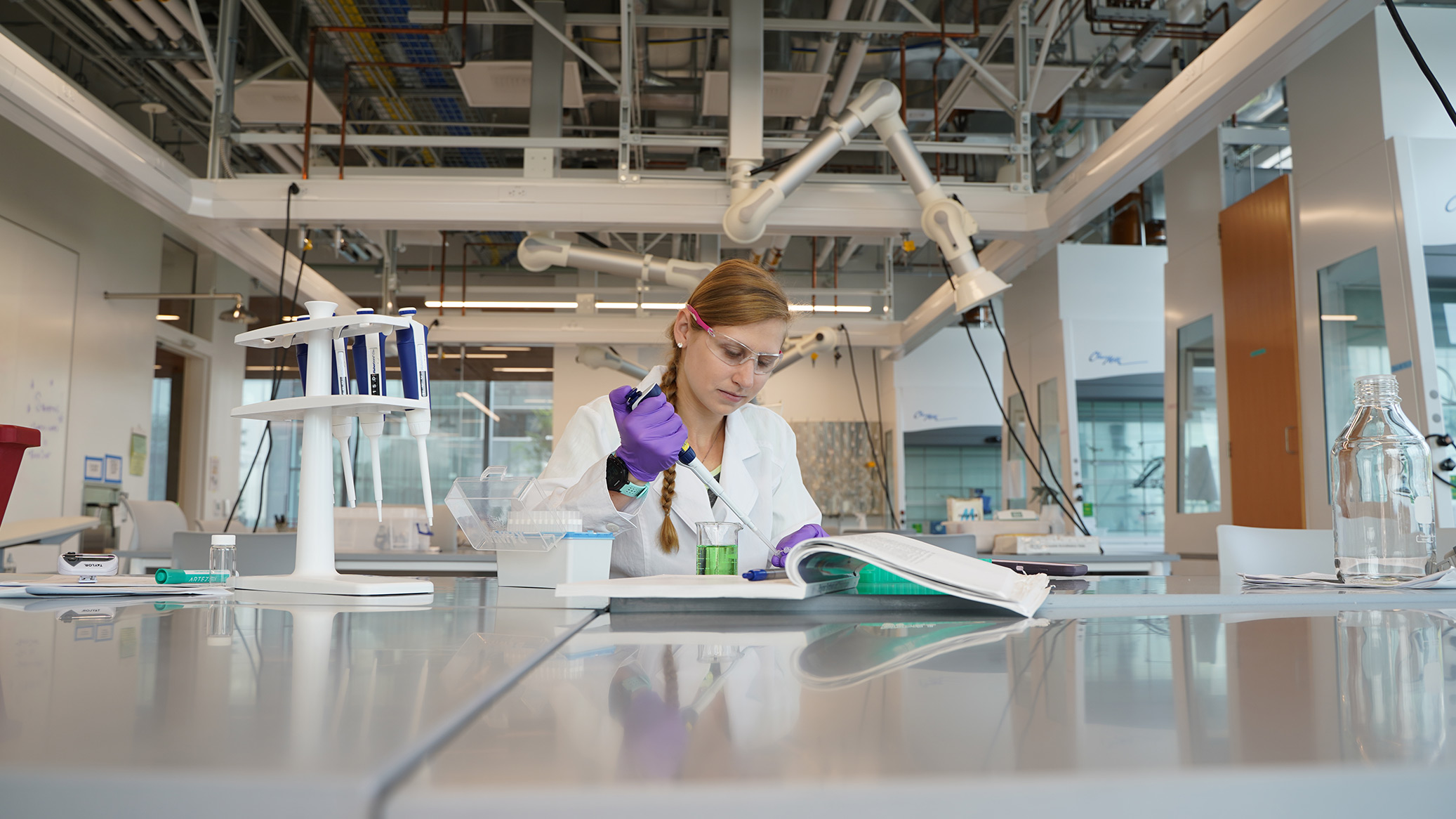 A researcher pipetting liquid at a lab bench