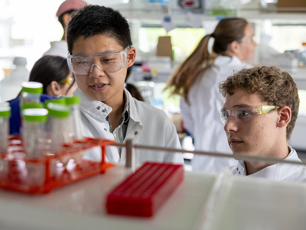 Two students examining an item in a lab