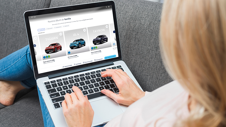 A woman sitting at a computer with a car shopping website on it