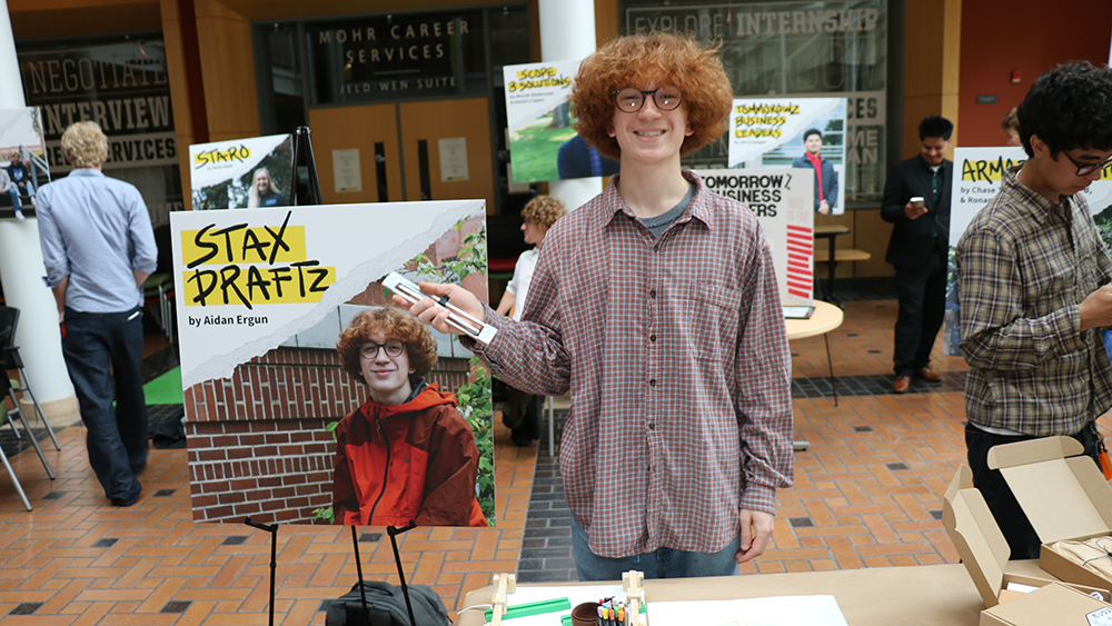 Student Aiden Ergon standing in front of his presentation at the Oregon Innovation Challenge