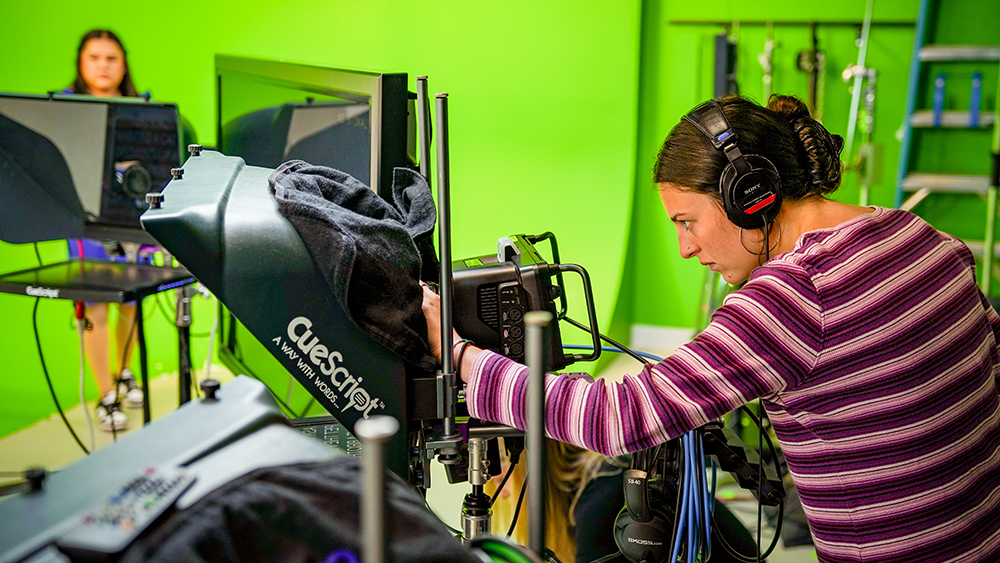 Student filming in a studio