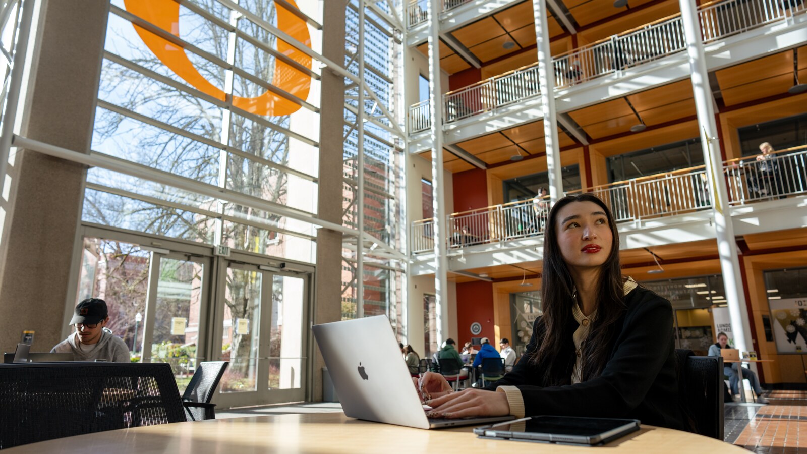 A student studies at a table inside Lillis Hall.
