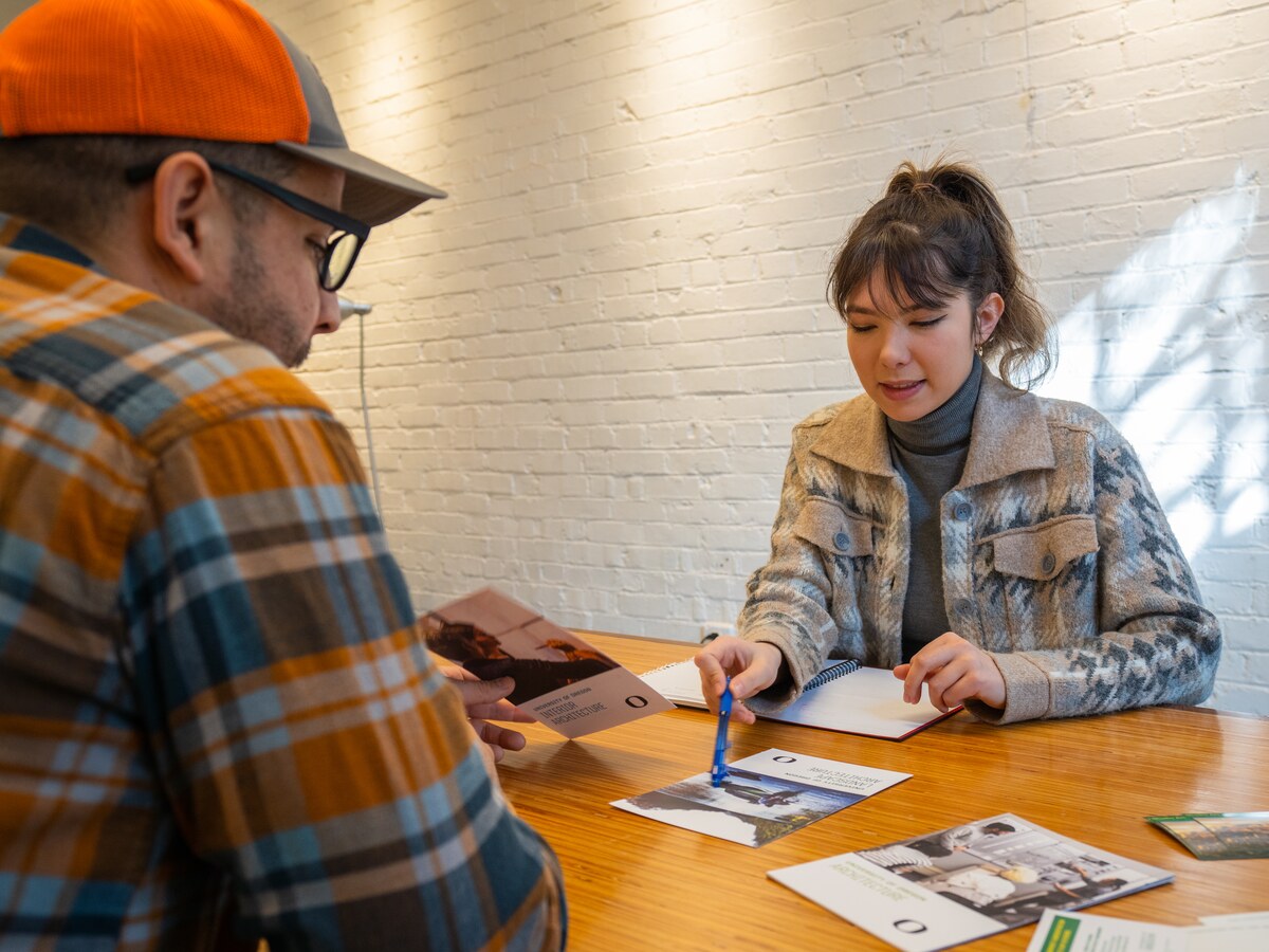 An adviser reviews a document with a student.