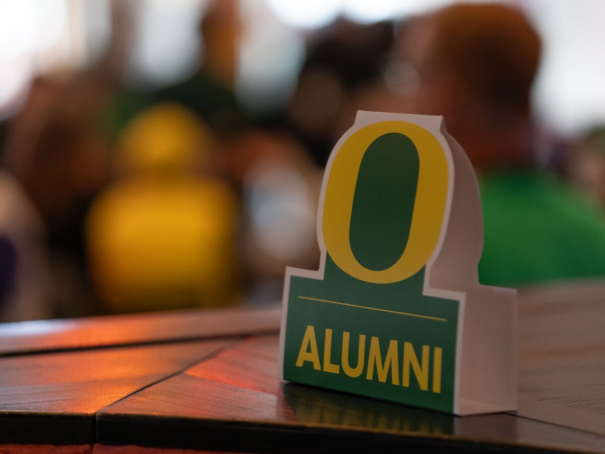 An Oregon Alumni display stands on a table at an event.