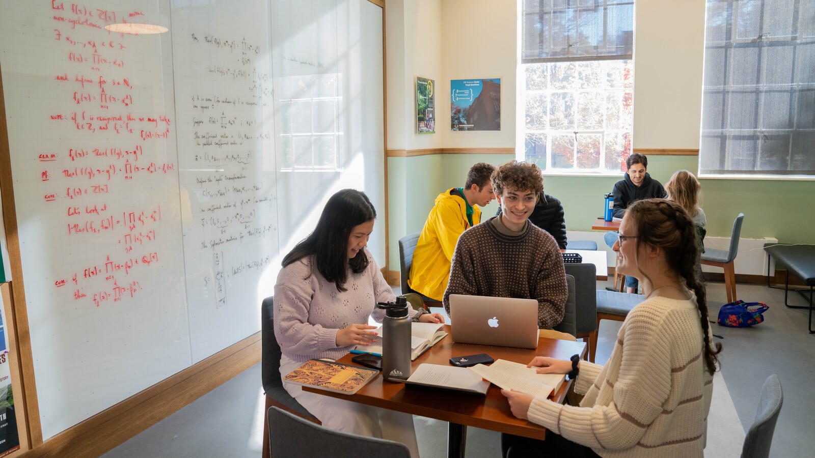 Clark Honors College students study together around a laptop.