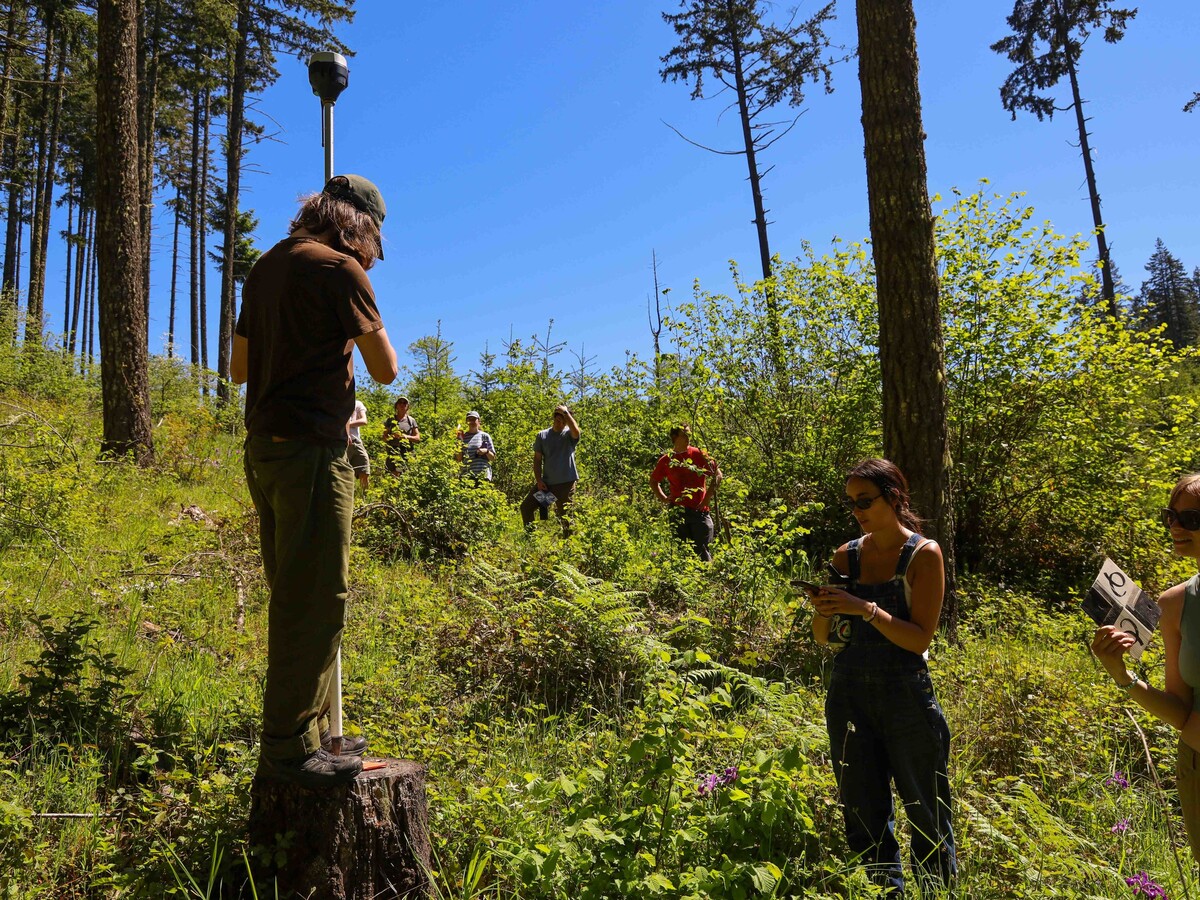 Students practice drone mapping in a wooded Oregon field.