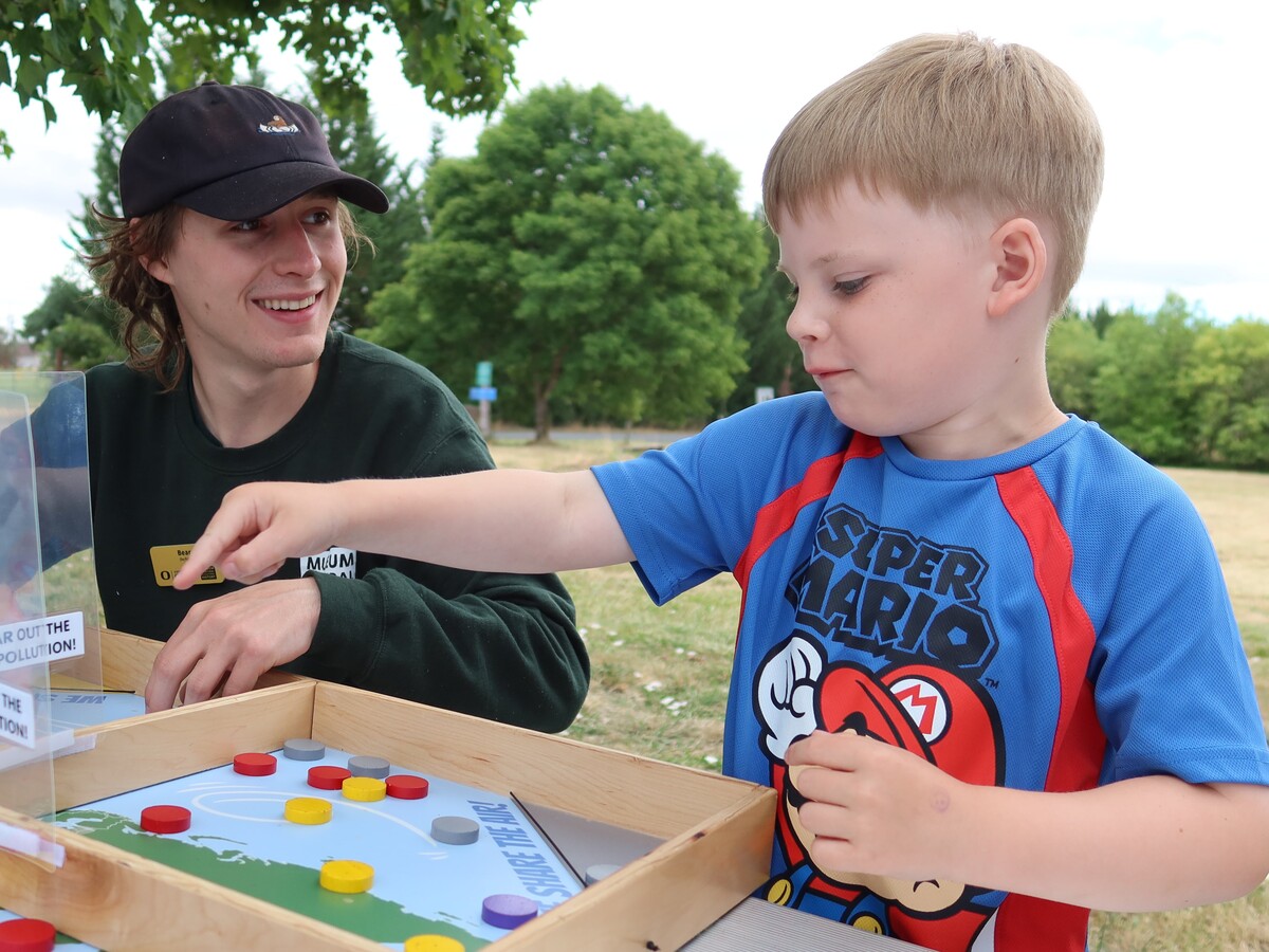 An adult guides a child through an air pollution activity.