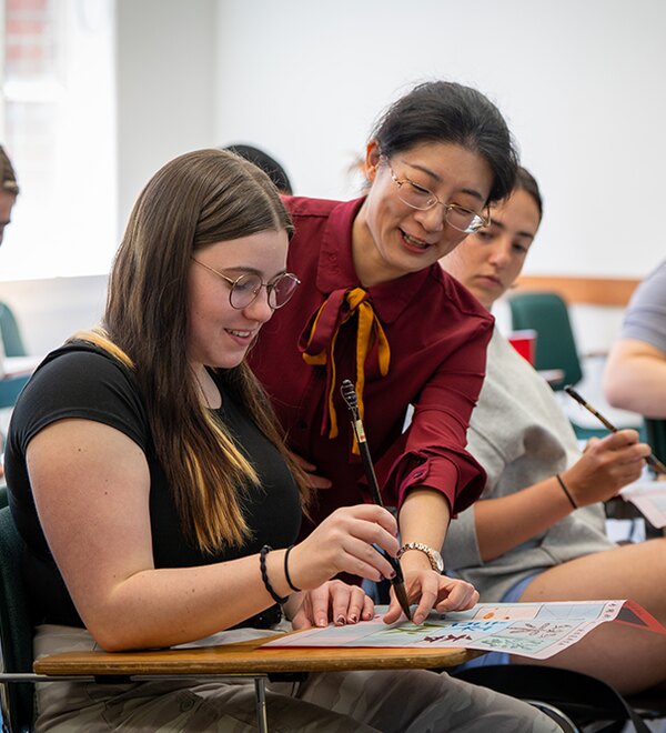 An instructor helps a student with a classroom activity.