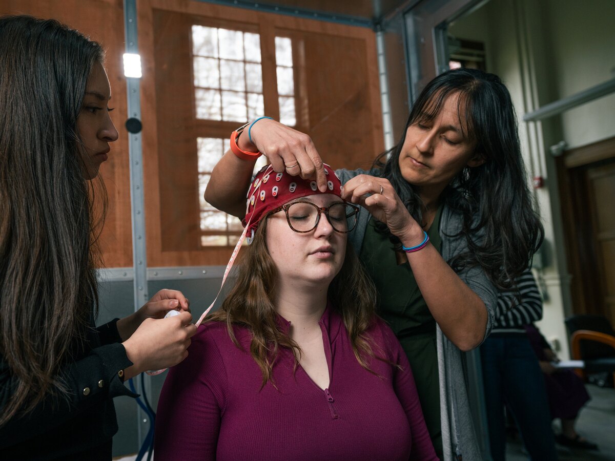 Researchers fit an electrode cap on a study participant.
