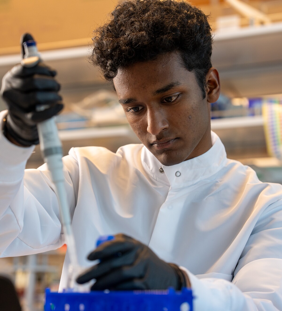 A student uses a pipette in a laboratory.
