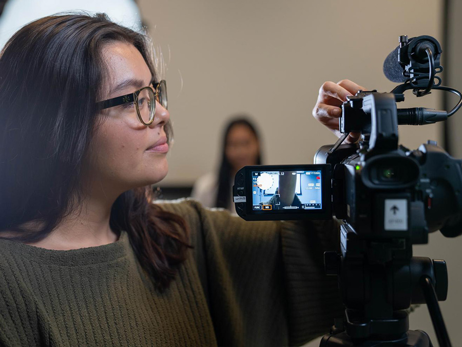 Journalism student sets up camera for interview