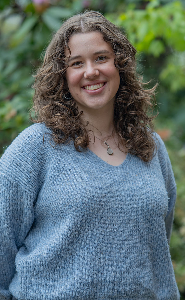 Mia Luscher poses outdoors on the University of Oregon campus.
