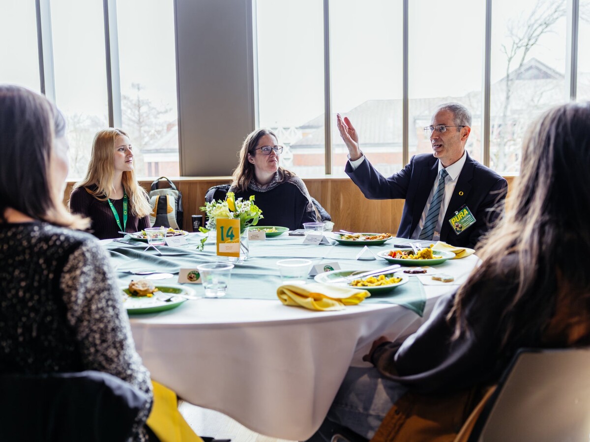 Provost Christopher Long talks with students at a PURA luncheon.