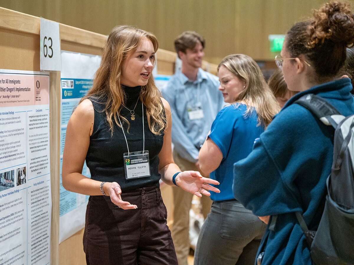 A student discusses her research poster at the Undergraduate Research Symposium.
