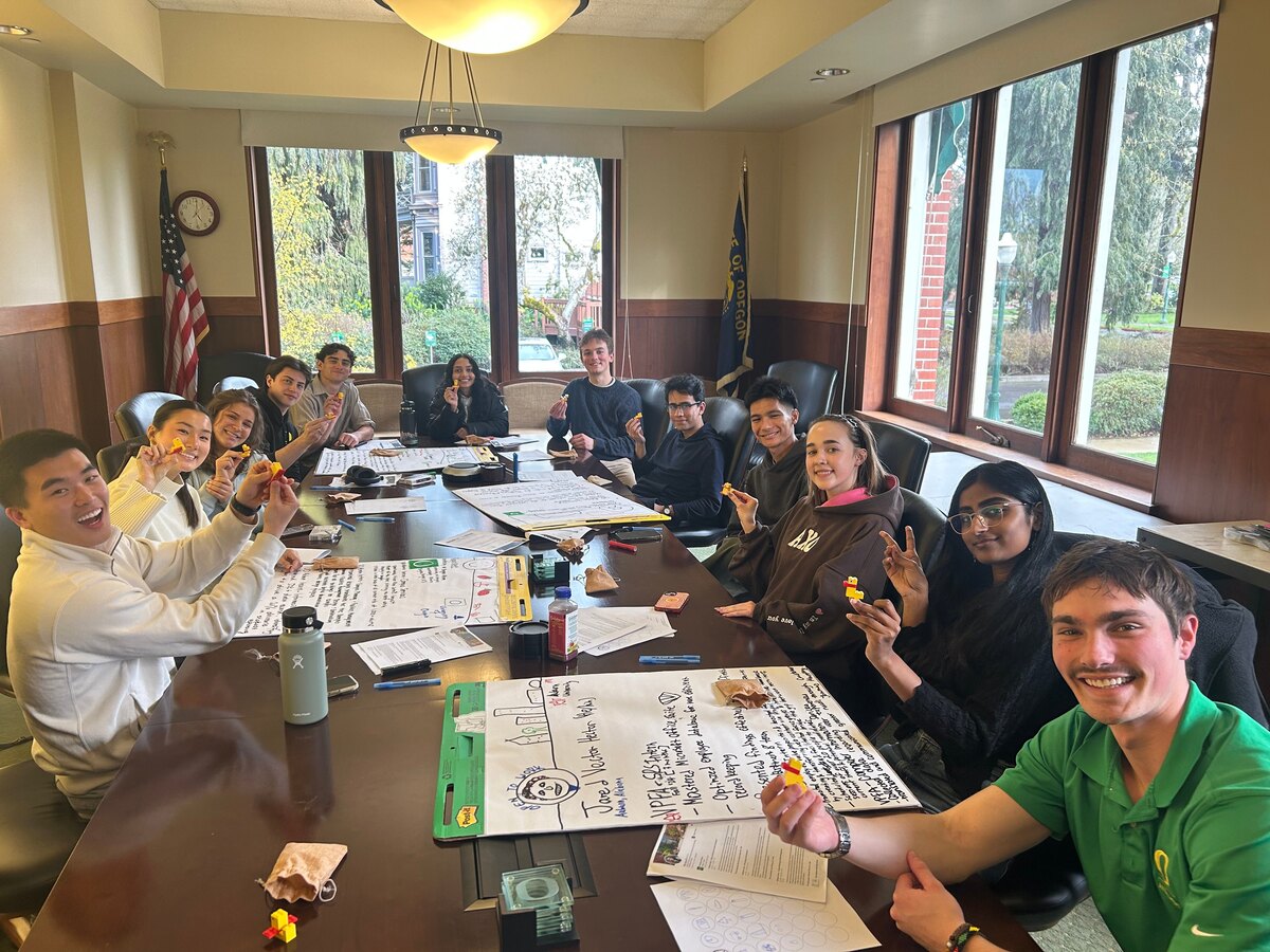 Students gather around a table during a collaborative workshop.