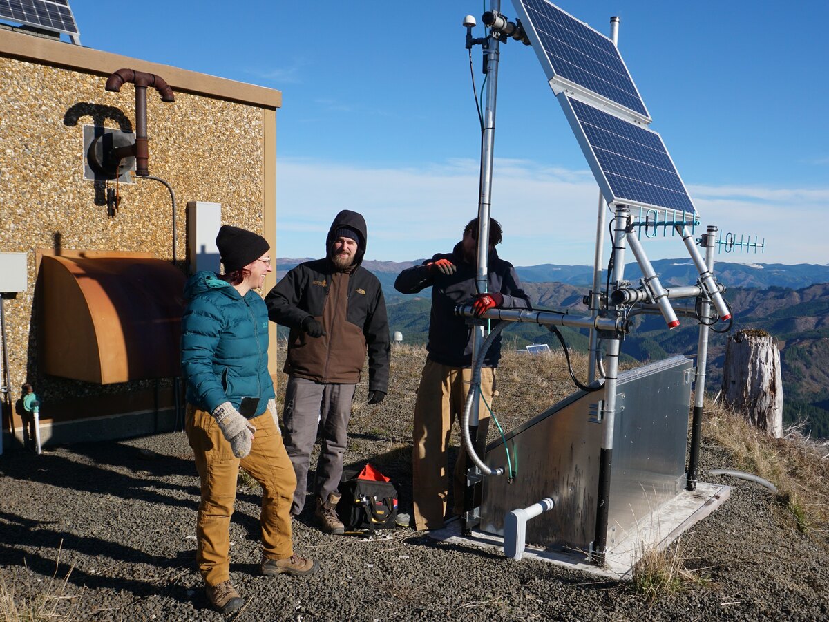 A team works with solar-powered monitoring equipment.