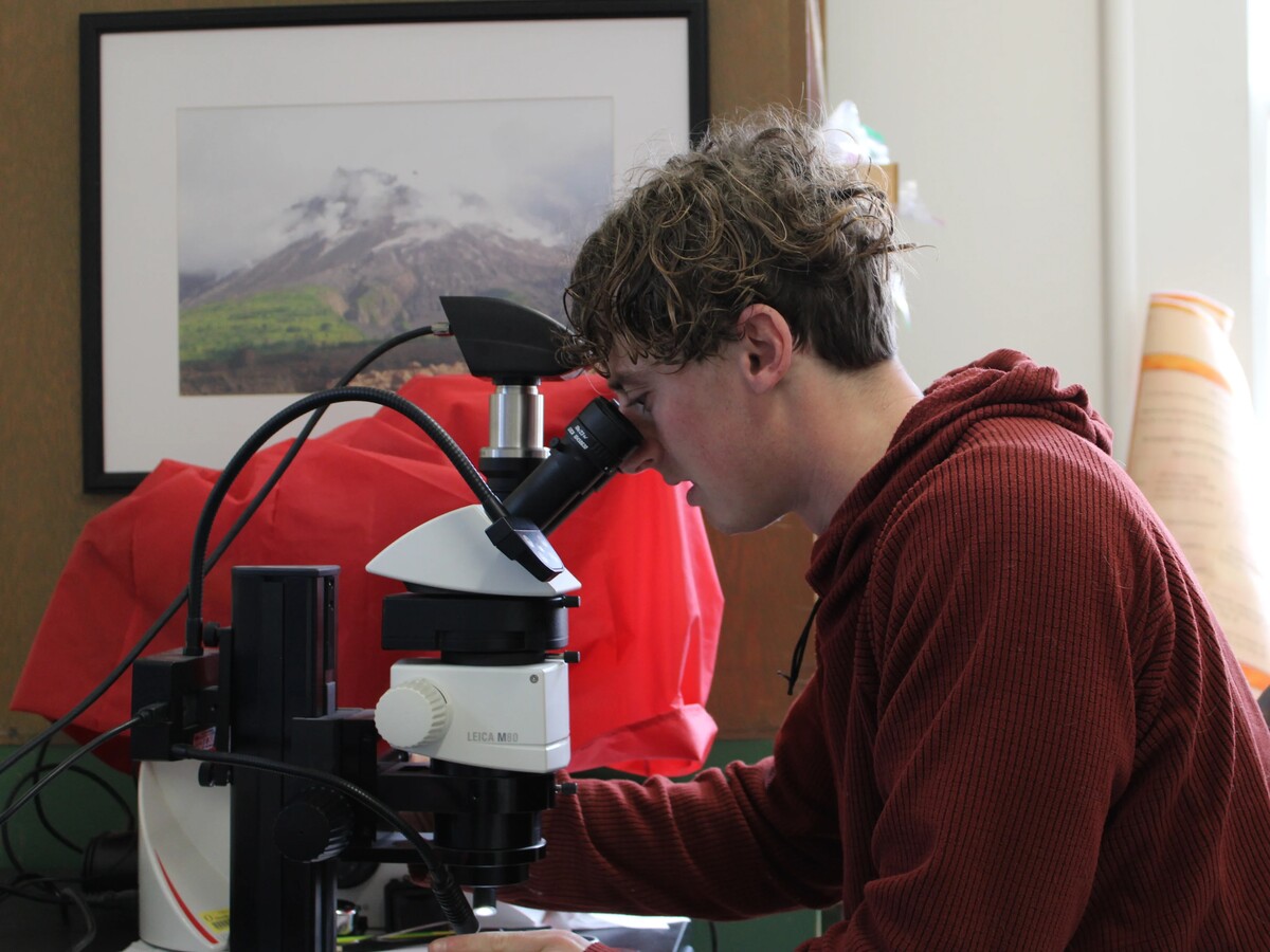 Marcus Chaknova examines a sample through a microscope.
