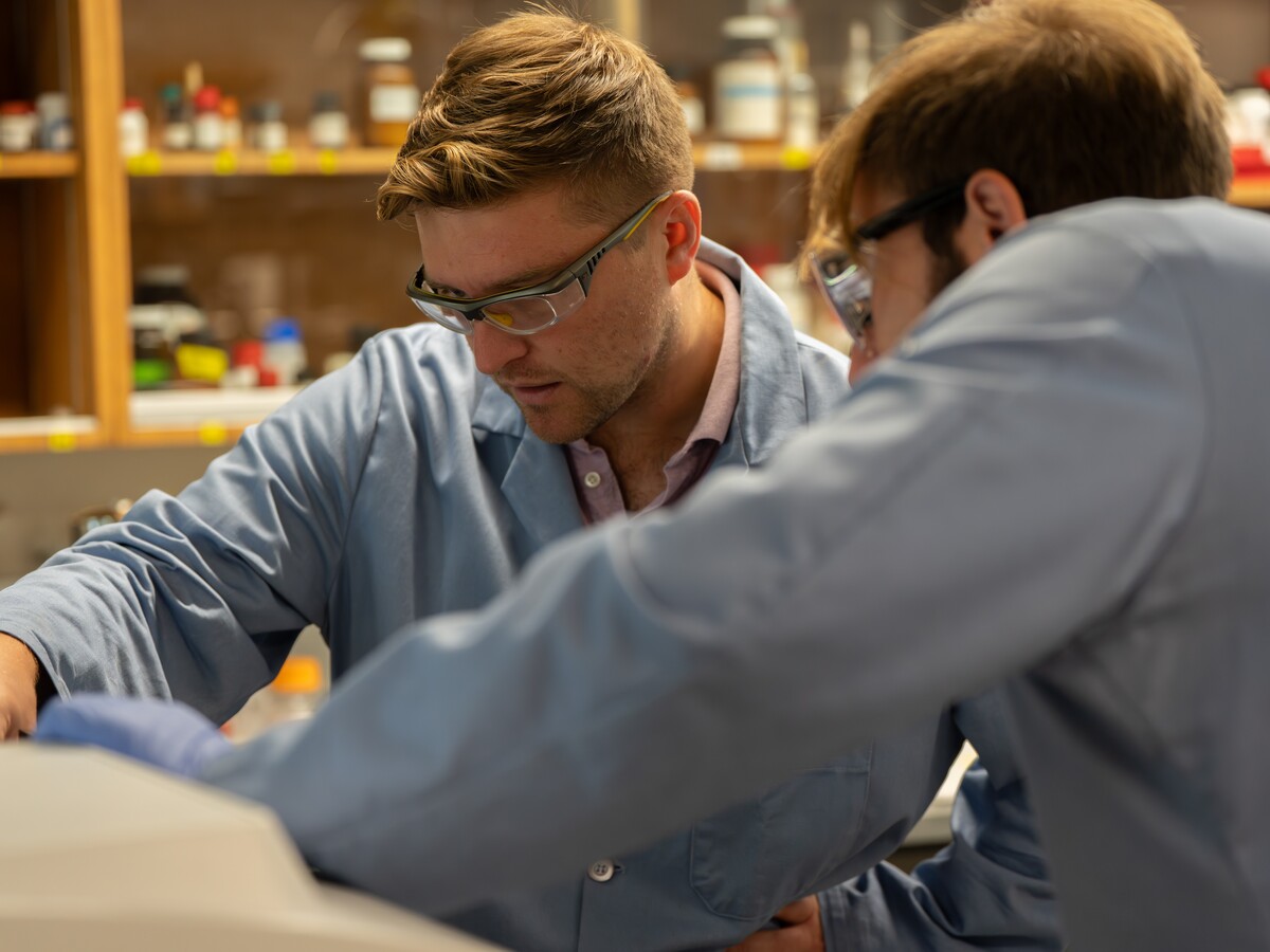 Carl Brozek and a graduate student review a spectrophotometer.