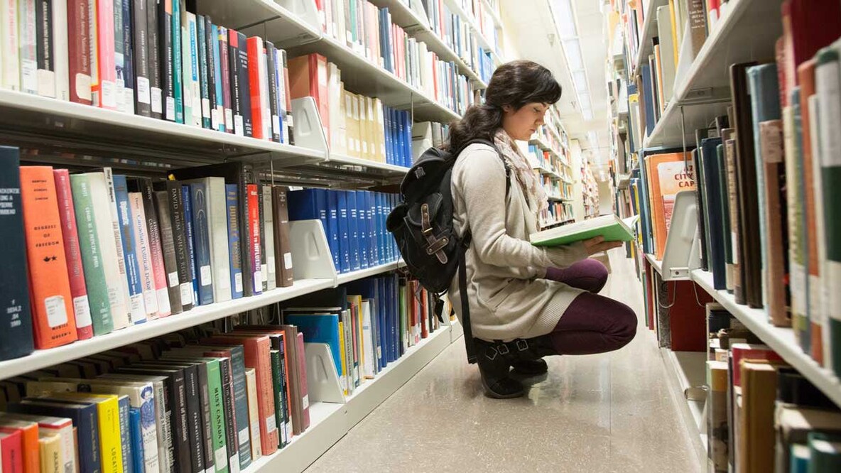 A student browses books in a campus library.