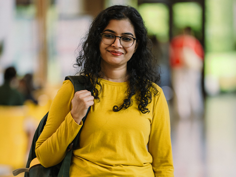 an international student wearing a yellow shirt and backpack