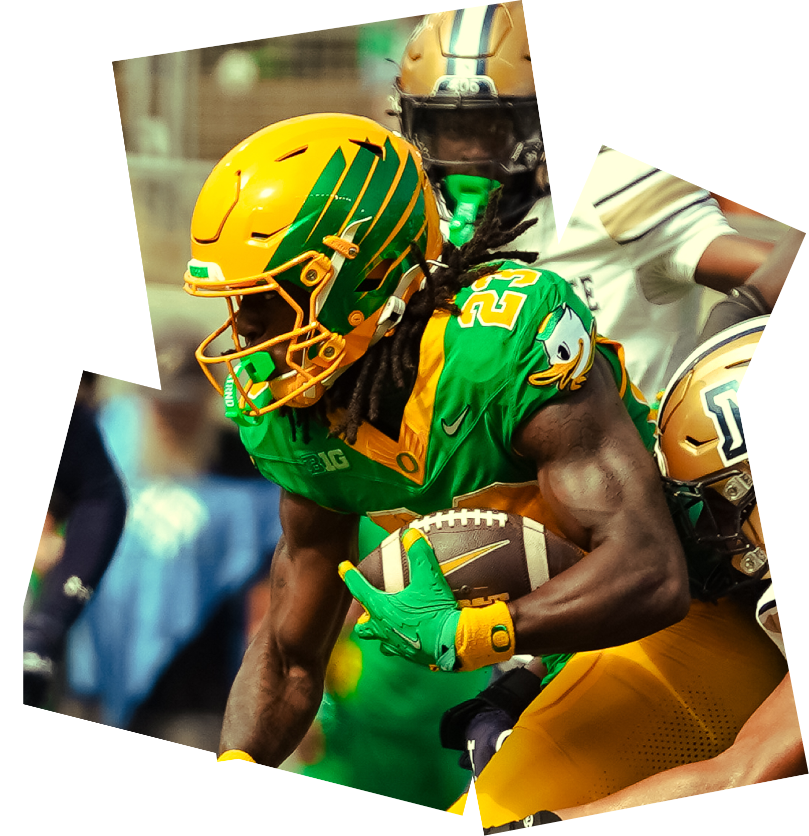 An Oregon football player carries the ball during a game.