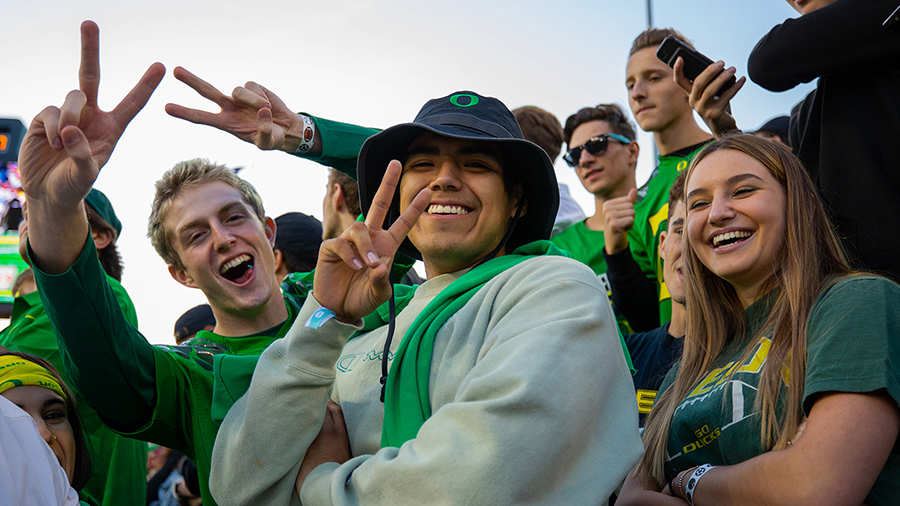 Students smiling in the stands at Autzen Stadium