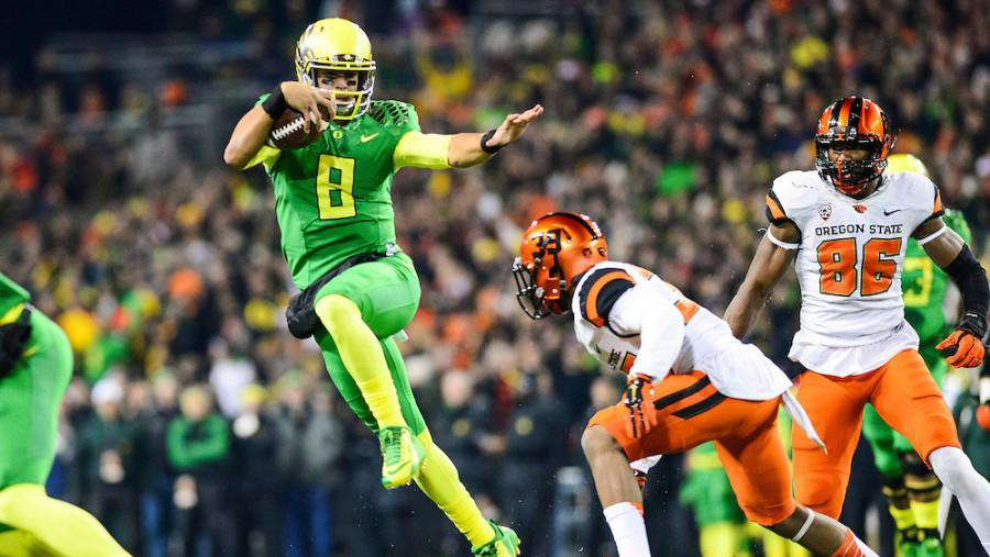 Marcus Mariota running with a football on a field in a game