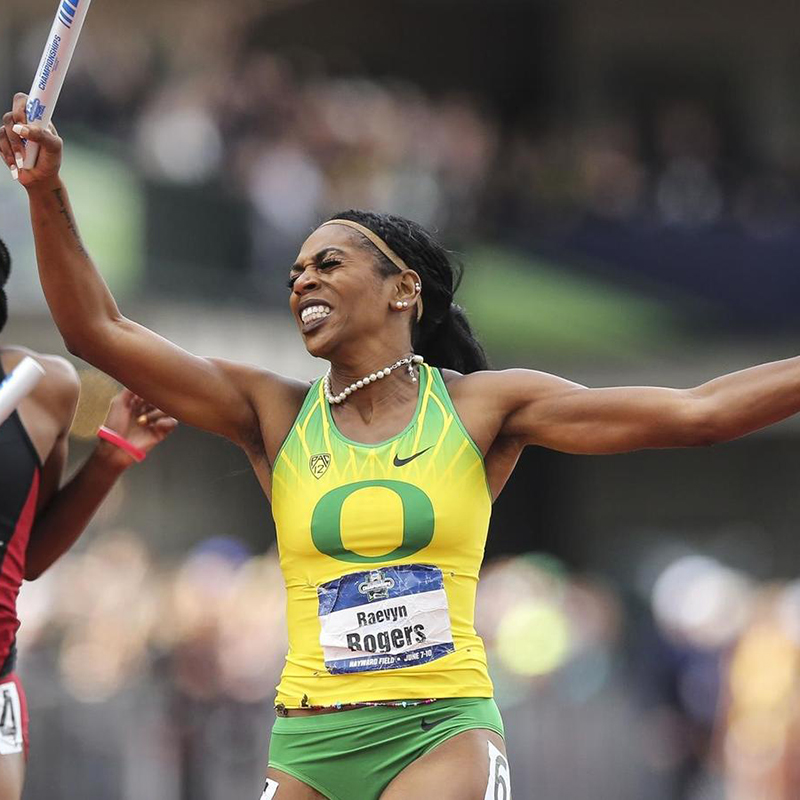 Raevyn Rogers holding a baton running on a track