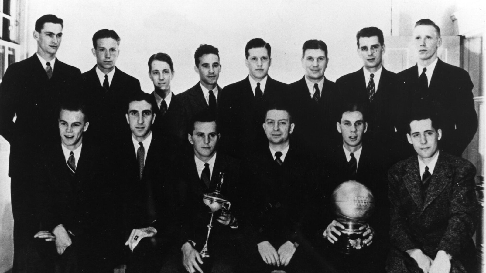 Oregon’s 1938–39 men’s basketball team poses with trophies.