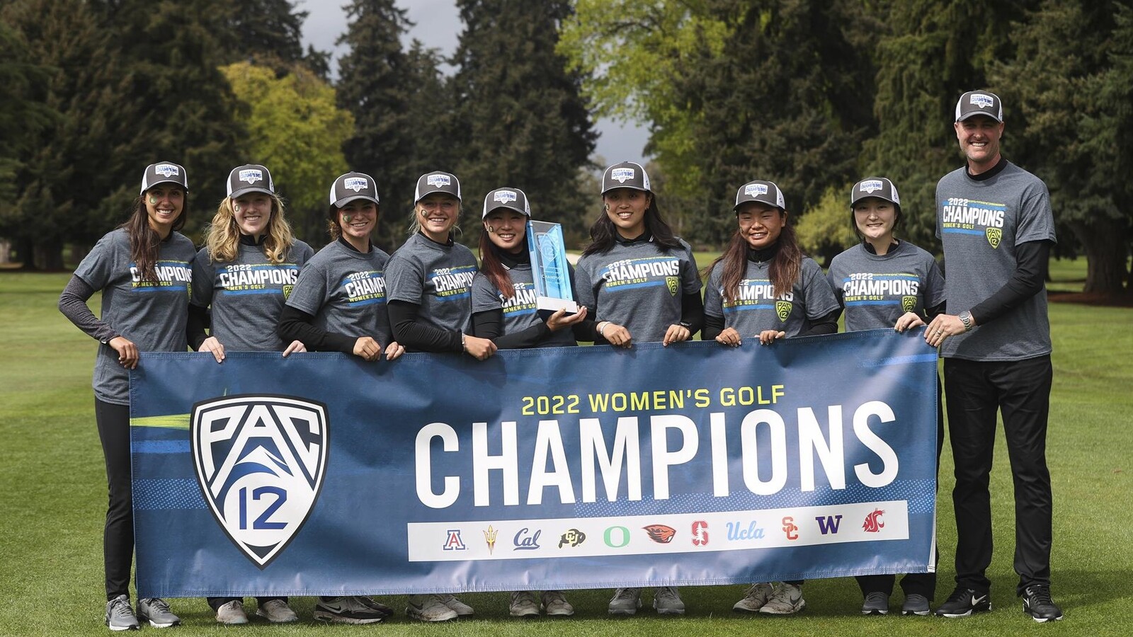 Oregon women’s golf team poses with the 2022 Pac-12 championship trophy and banner.