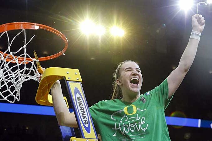 Sabrina Ionescu celebrates beside a basketball hoop after reaching the Final Four.