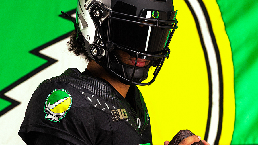 An Oregon football player wearing a black uniform with the Grateful Duck patch on the shoulder.