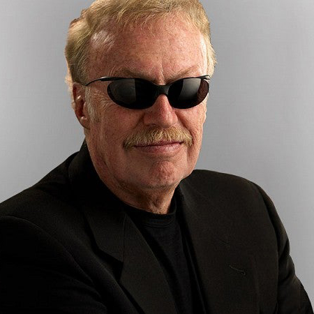 Phil Knight poses against a gray background.