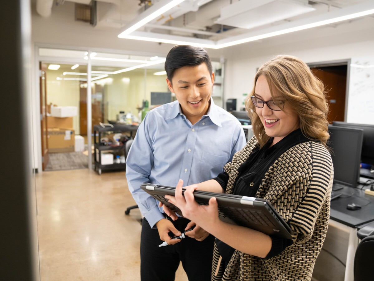 Two researchers review work on a laptop in a University of Oregon laboratory.