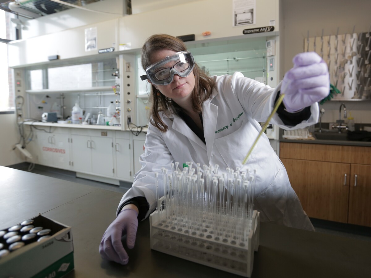 A researcher transfers a sample with a pipette.