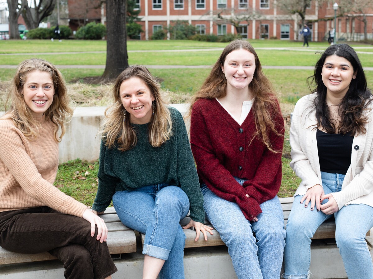 Four women pose together on the University of Oregon campus.