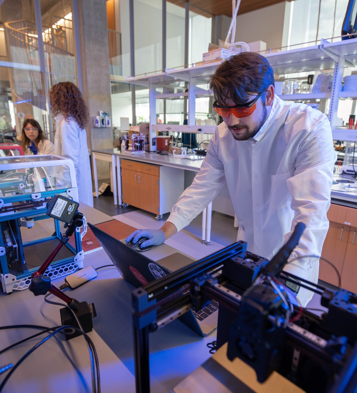 A researcher operates custom equipment in a Knight Campus laboratory.