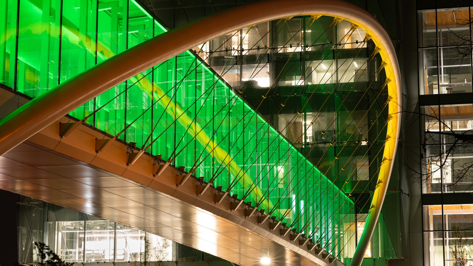 A green-lit bridge spans the Knight Campus atrium.