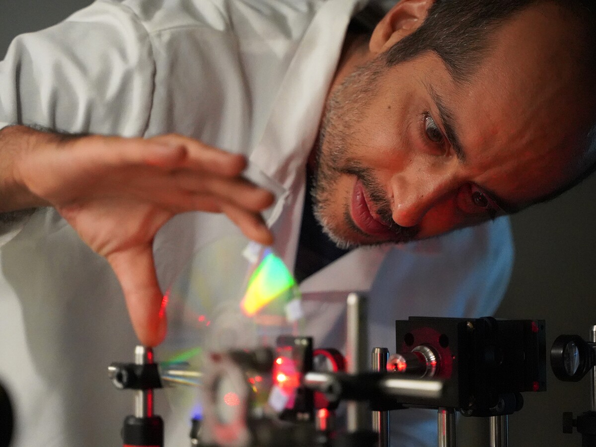 A researcher adjusts a laser setup in a laboratory.