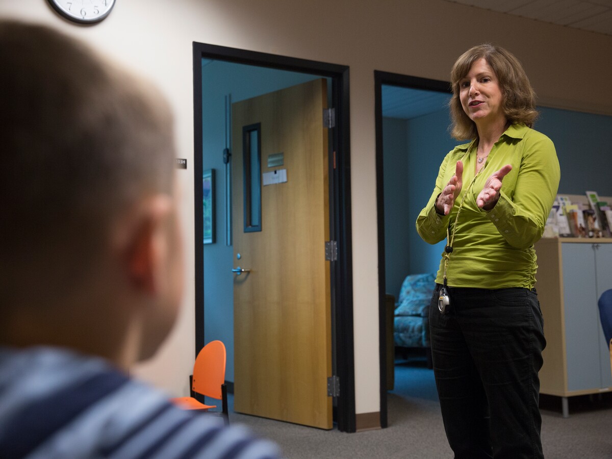 A researcher works with a child in a behavioral health study.