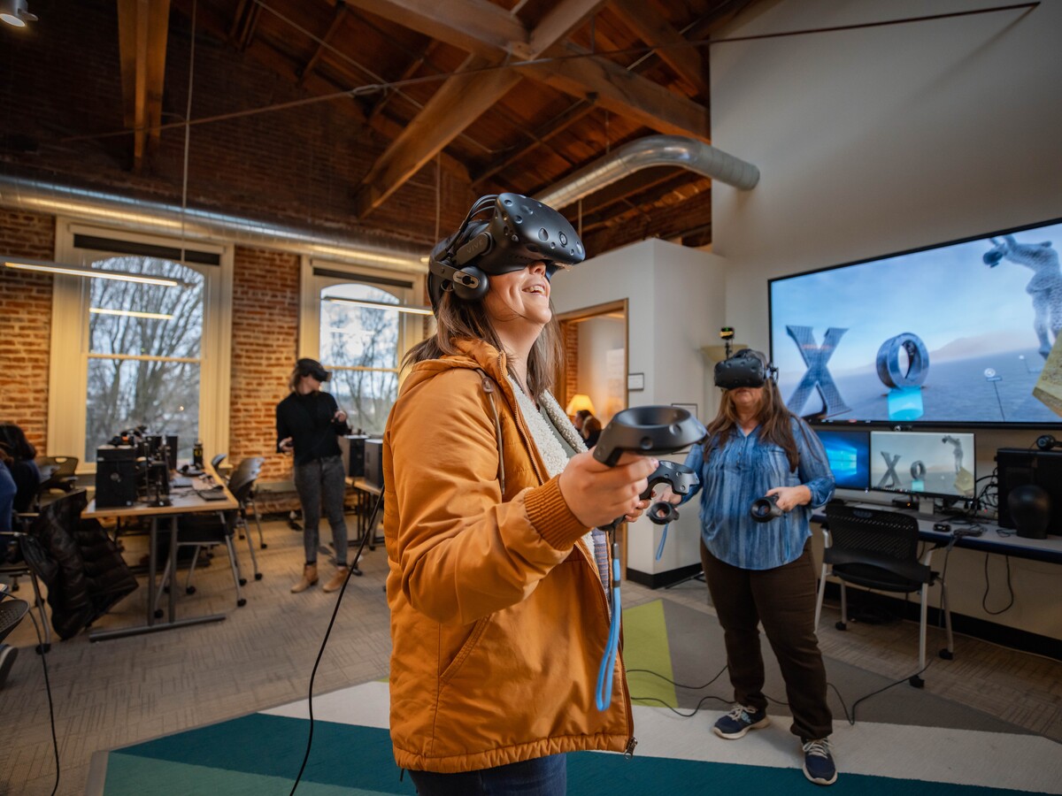 Three people use virtual reality headsets in a research lab.