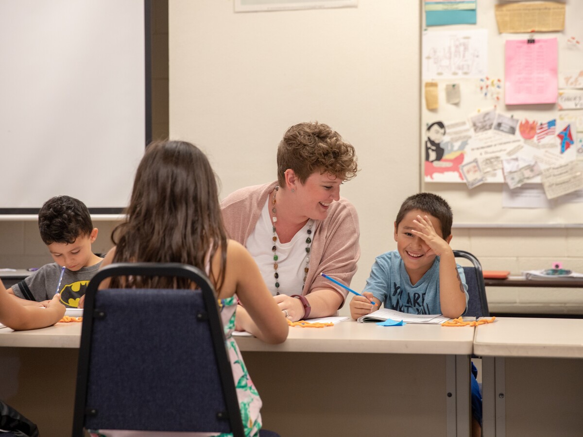 Graduate students work with children in a classroom.