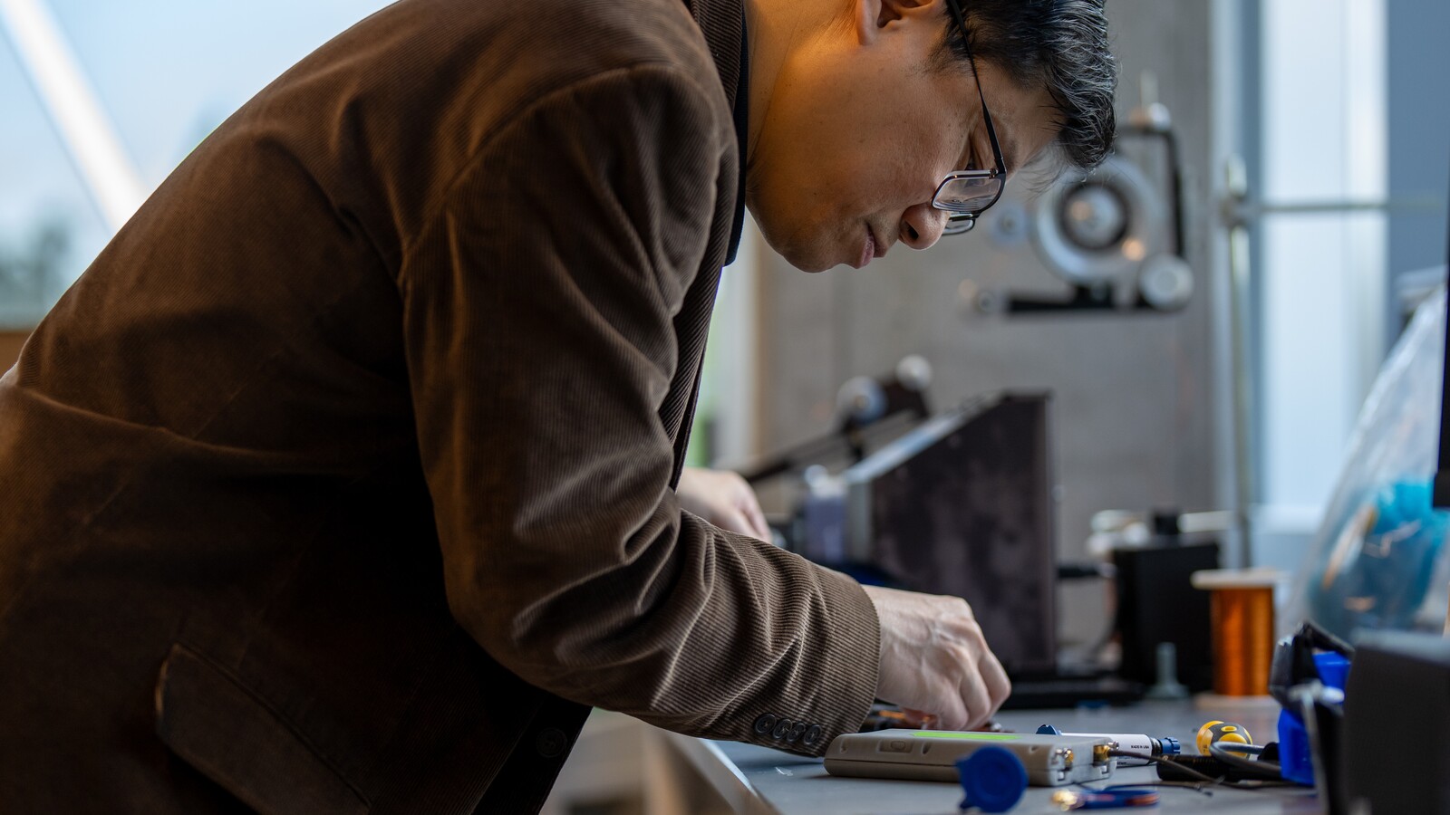 A researcher assembles a prototype at a laboratory workbench.